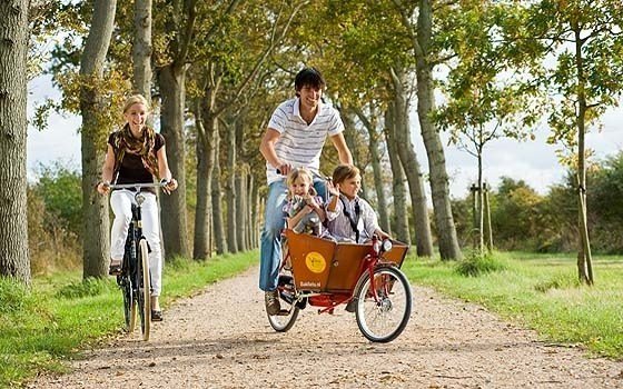 A cycling family with a waving boy