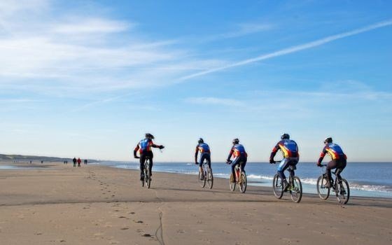 Group of cyclists on the beach of Noordwijk