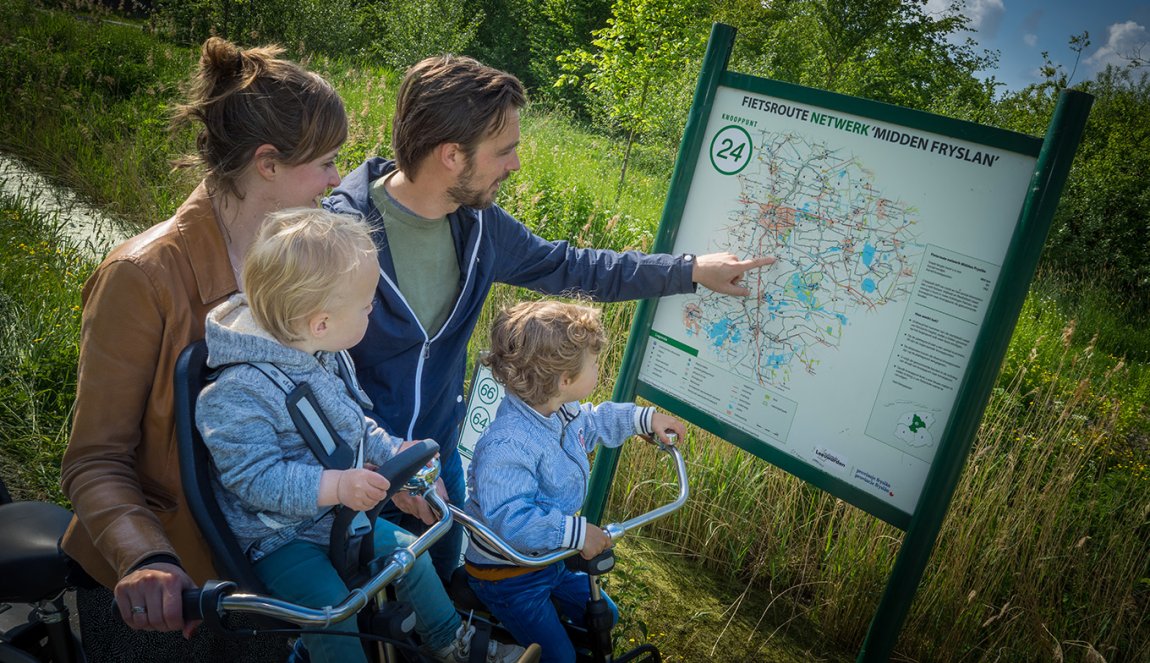 Family looks at sign cycling route network Central Friesland