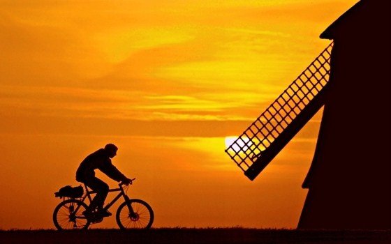 Silhouette of a Mill and Cyclist at sunset