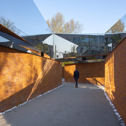 Visitor views walls full of names at Namenmonument Amsterdam