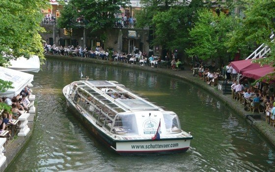 People enjoying their meal while a boat floats by