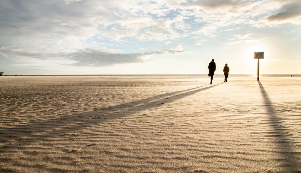 Wadden Sea people walk on the beach setting sun 