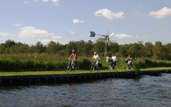 People cycling alongside the water