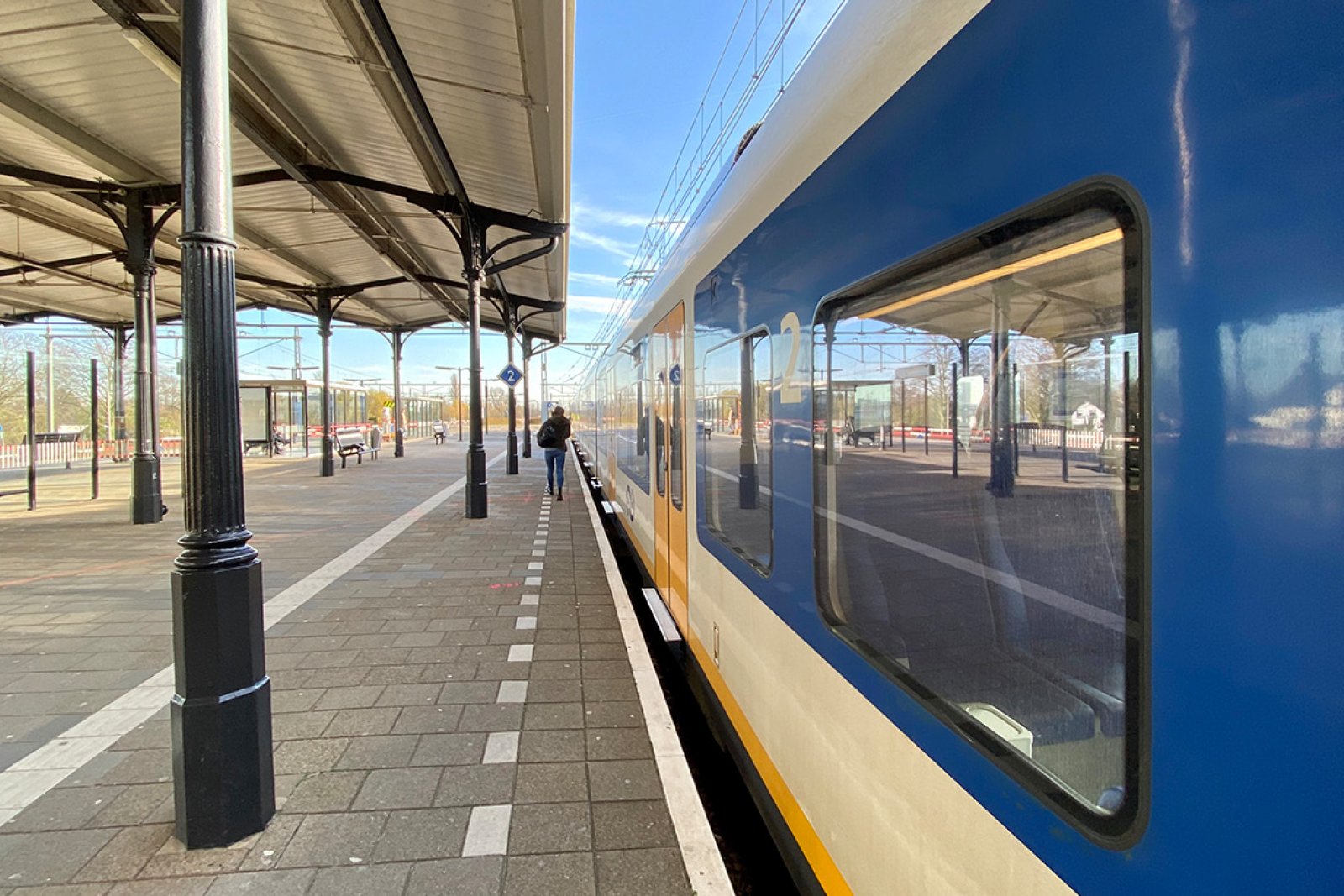 Someone walks to the train at NS station Geldermalsen