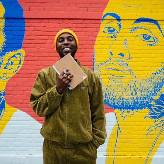 Portraitphoto Elten Kiene with booklet for colorful graffiti wall