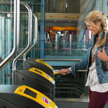 Lady opens gate with public transport chip card 