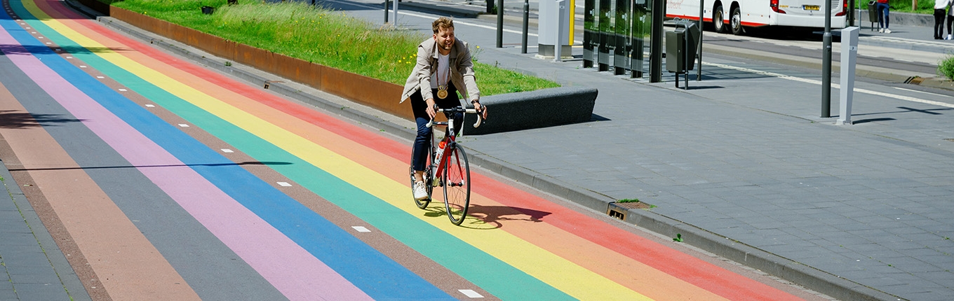 Jelle Bakker on a bike in Utrecht over rainbow bike path Jelle Bakker on a bike in Utrecht over rainbow bike path