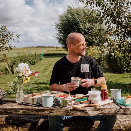 Man enjoys table full of local produce at the Zuiderkrib Dijkhuisje in Kraggenburg, Flevoland