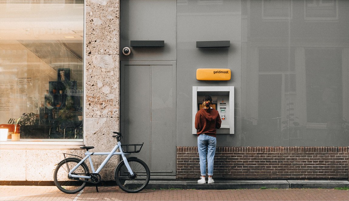 Lady parked her bike to withdraw money at Geldmaat (Dutch ATM)