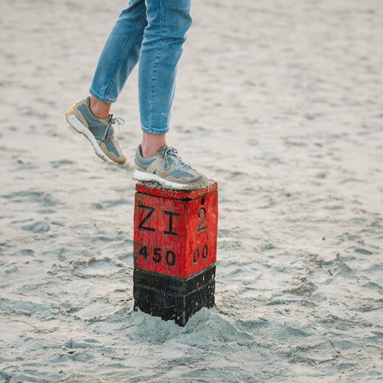 Lady foot on pole in sand on beach in Schiermonnikoog Friesland