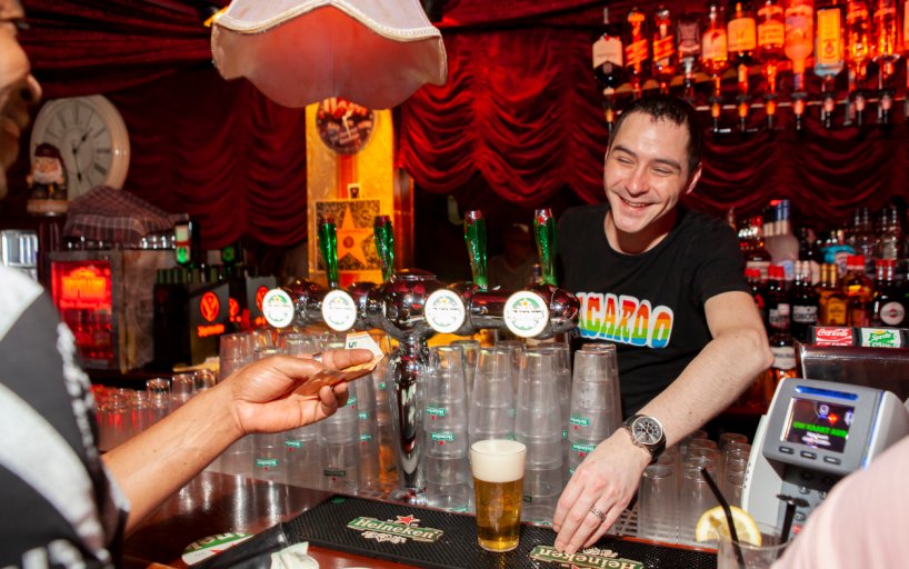 Bartender serves beer in gay bar Rotterdam