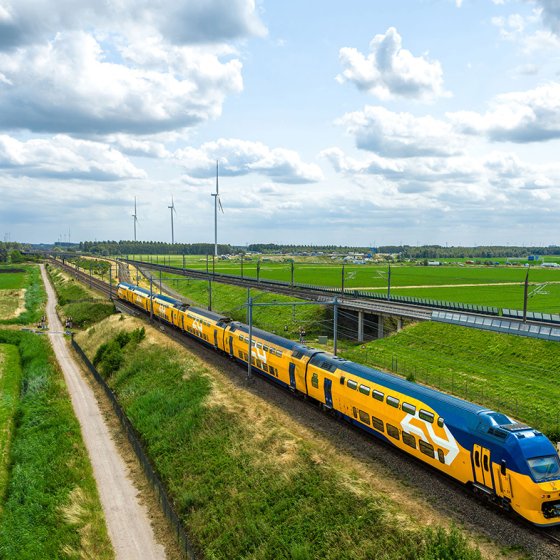 NS train through Dutch landscape with windmills