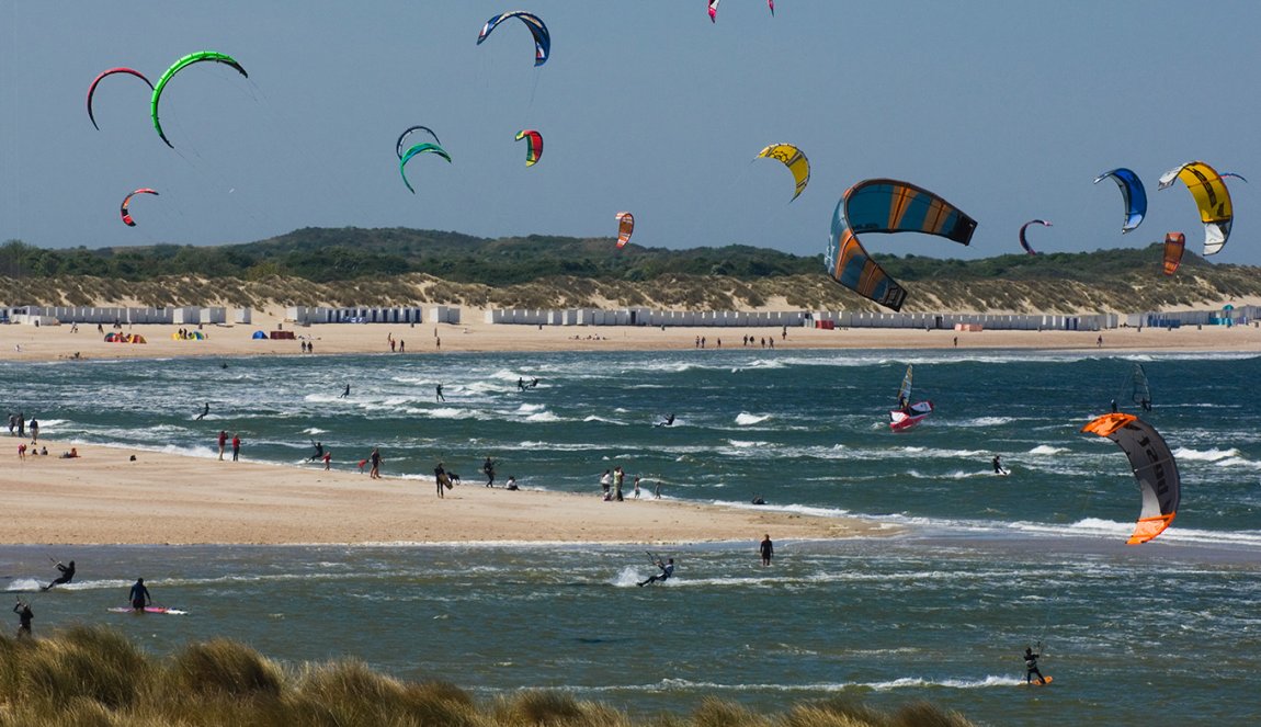 Kitesurfers at sea with beach and beach houses
