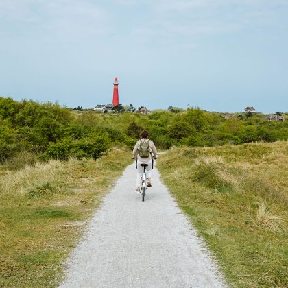 Cyclist on Schiermonnikoog with the lighthouse in view