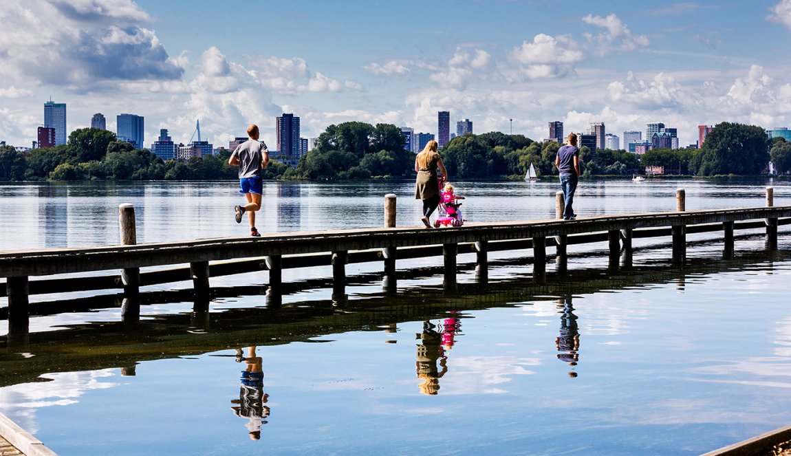 Kralingen-Crooswijk: Recreationists walk across a jetty at Kralingse Plas 