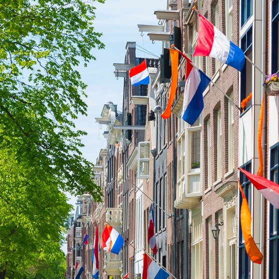 Canal houses with Dutch flags and orange pennant during King's Day
