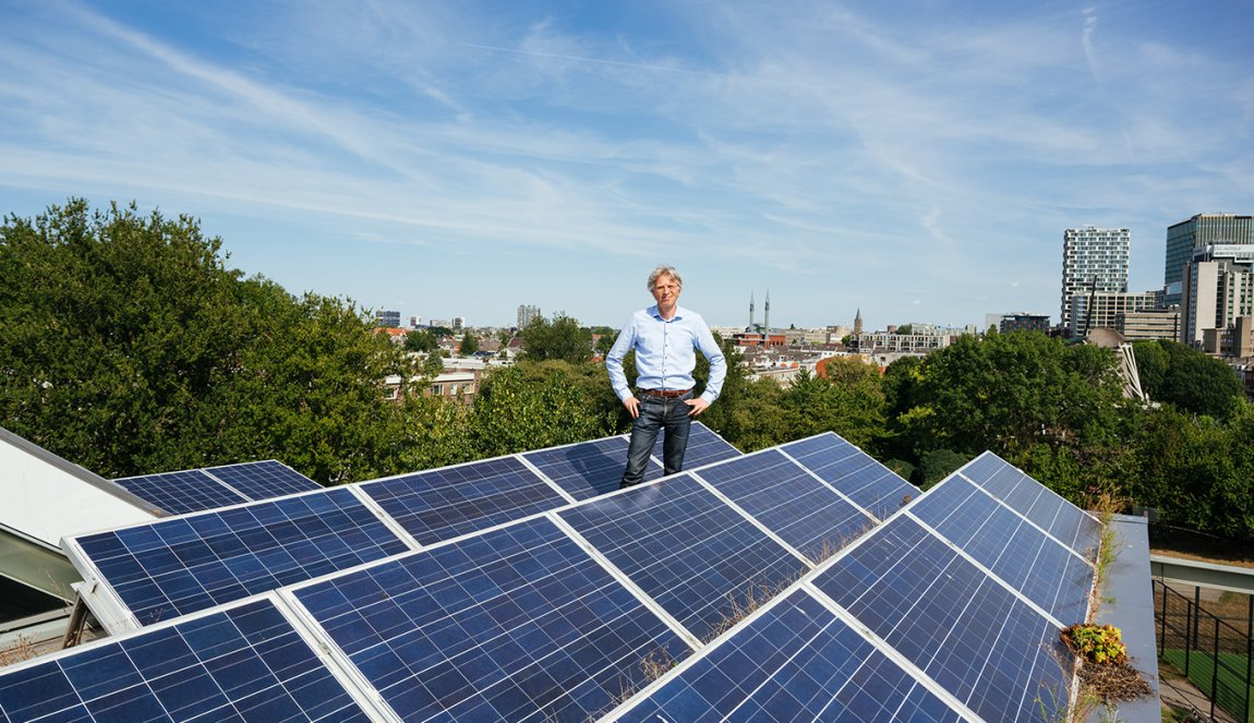Portrait Robin Berg We Drive Solar standing on the roof with solar panels