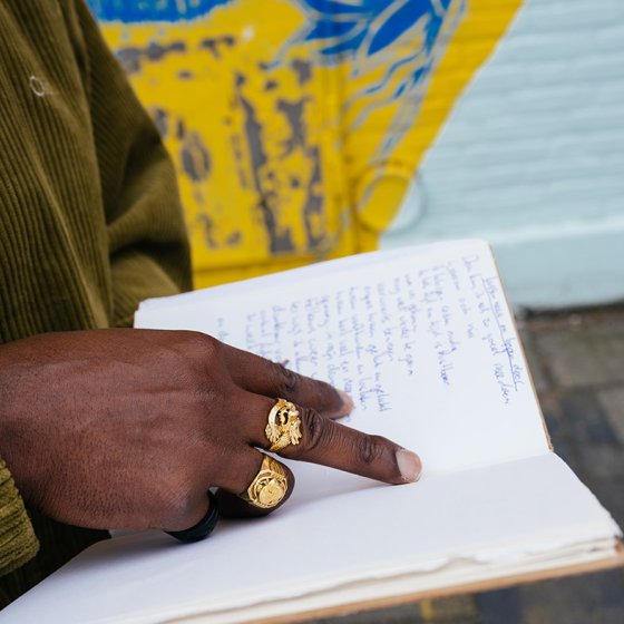 Portraitphoto Elten Kiene holding book in hands with large gold rings