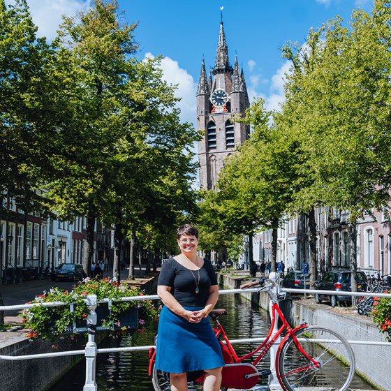 Melissa Bruntlett with bike at the canal Oude Delft backdrop The Old Church