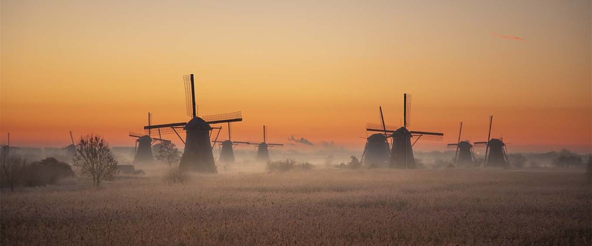 The windmills of Kinderdijk in the light of morning glory with a sunrise.