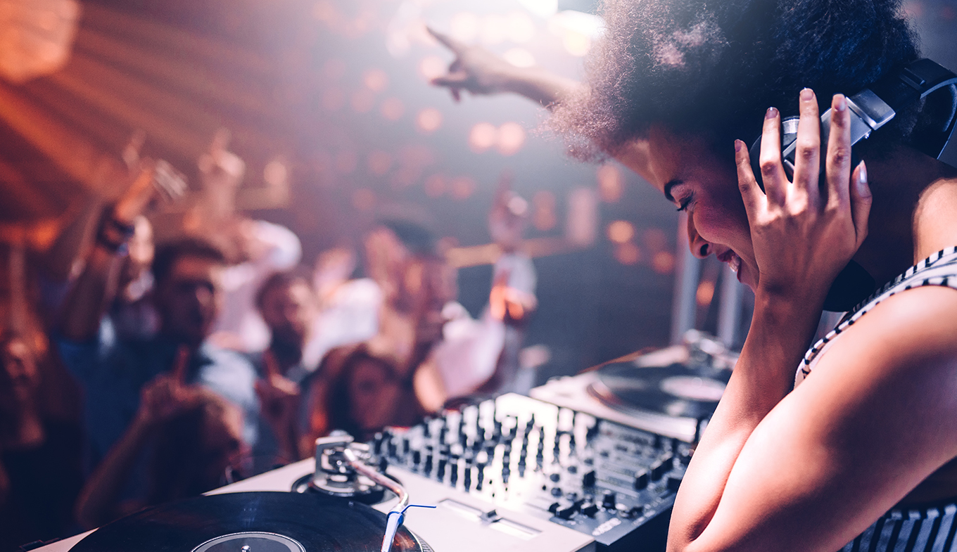 Nightlife female DJ in club with people dancing Nightlife female DJ in club with people dancing