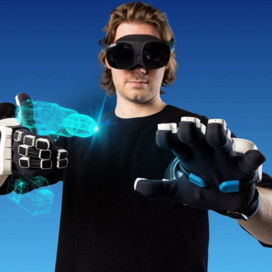 Person demonstrating SenseGlove haptic gloves and a VR headset for interacting with virtual objects