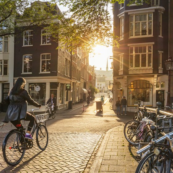 People riding bicycles through downtown Amsterdam. Sunlight and silhouettes