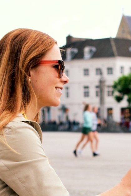 Woman enjoying an ice cream at Vrijthof square in the historic centre of Maastricht