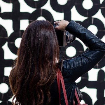 Woman takes photo in STRAAT museum with red bag
