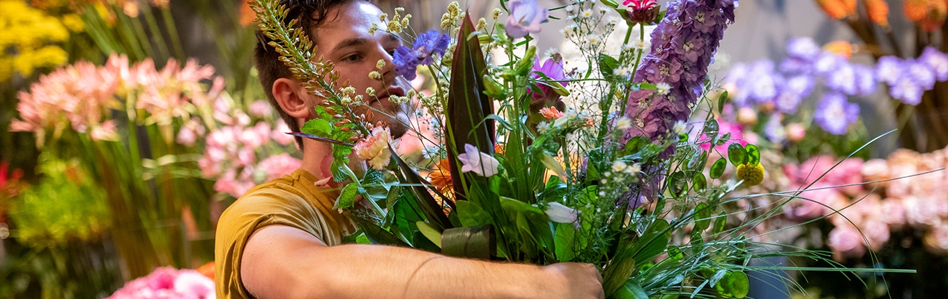 Arranging flowers. Big bunch of flowers in arms.