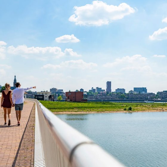 Couple walks across bridge with skyline Veur-Lent Nijmegen