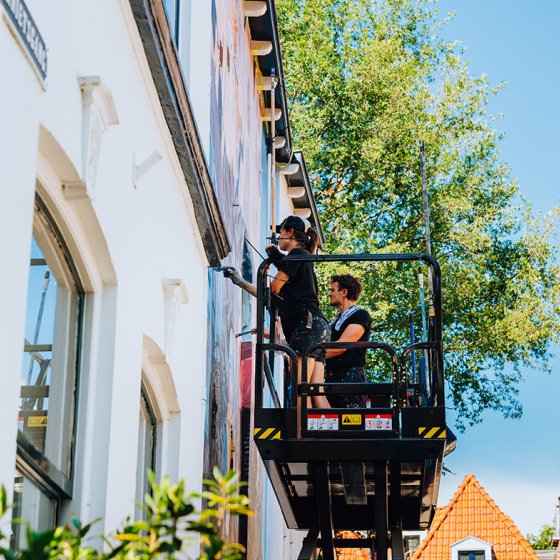 Graffiti artists at work on outdoor platform