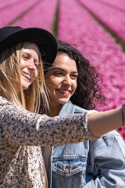 Ladies take selfie next to tulip field