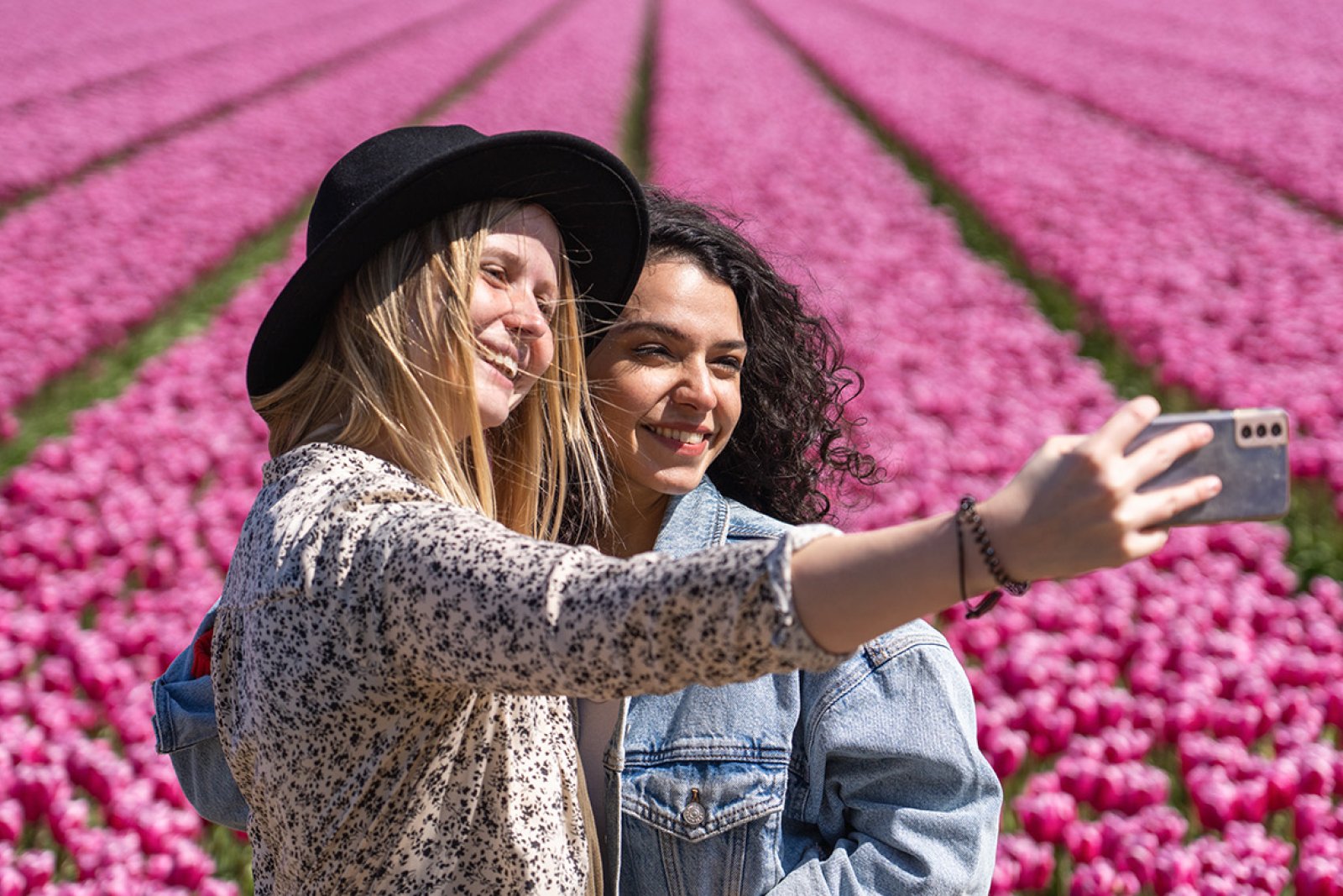 Ladies take selfie next to tulip field