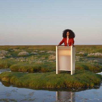 Businesswoman behind presentation desk in Frisian landscape