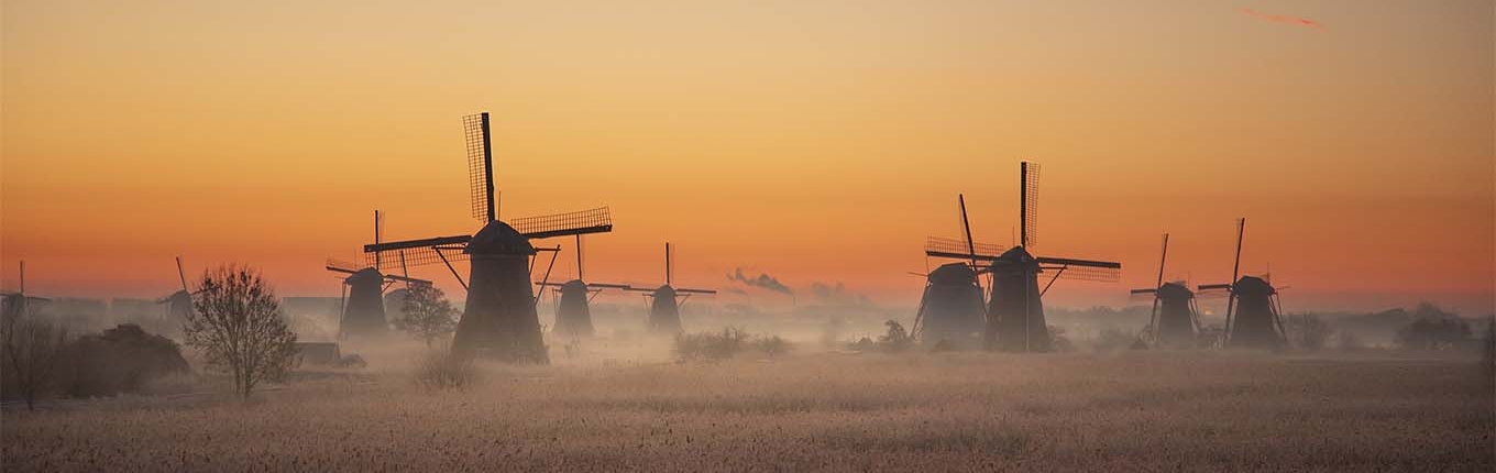 The windmills of Kinderdijk in the light of morning glory with a sunrise.