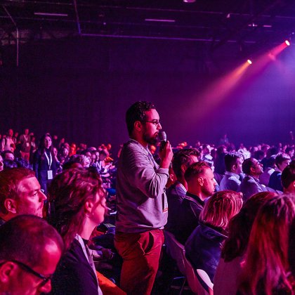Audience member asking a question during a large business conference in the Netherlands