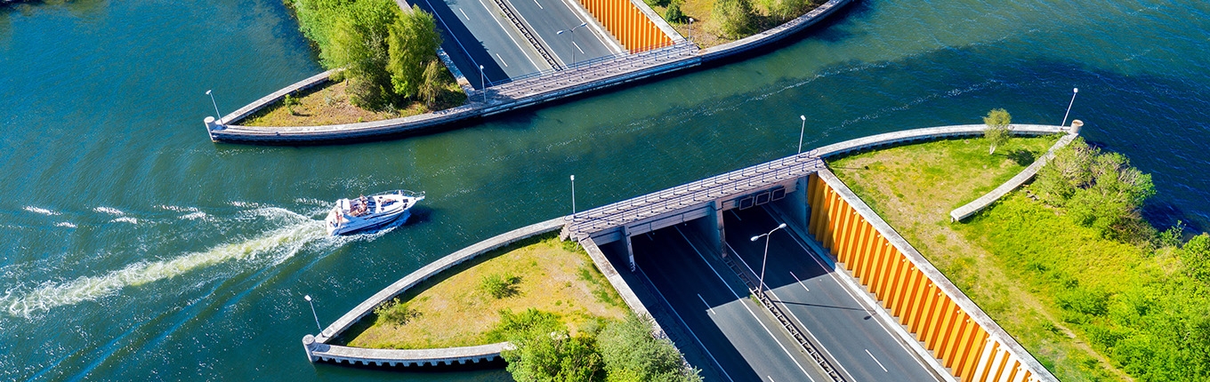 Aqueduct Veluwemeer, aerial view from the drone. A sailboat sails through the aqueduct on the lake above the highway Harderwijk Aqueduct Veluwemeer, aerial view from the drone. A sailboat sails through the aqueduct on the lake above the highway Harderwijk