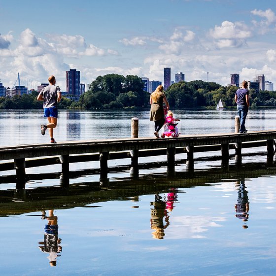 Kralingen-Crooswijk: Recreationists walk across a jetty at Kralingse Plas 