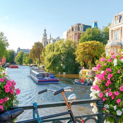 Amsterdam canals with boats view from a bridge with a bike