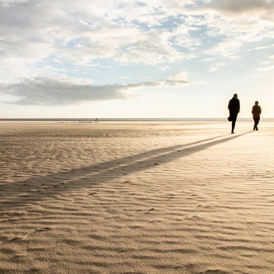 Wadden Sea people walk on the beach setting sun 