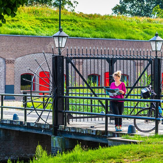 Cyclist looking at a map of the New Dutch Waterline - Fort Voordorp
