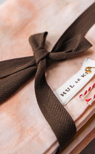 Hul le Kes stack of textiles with bow
