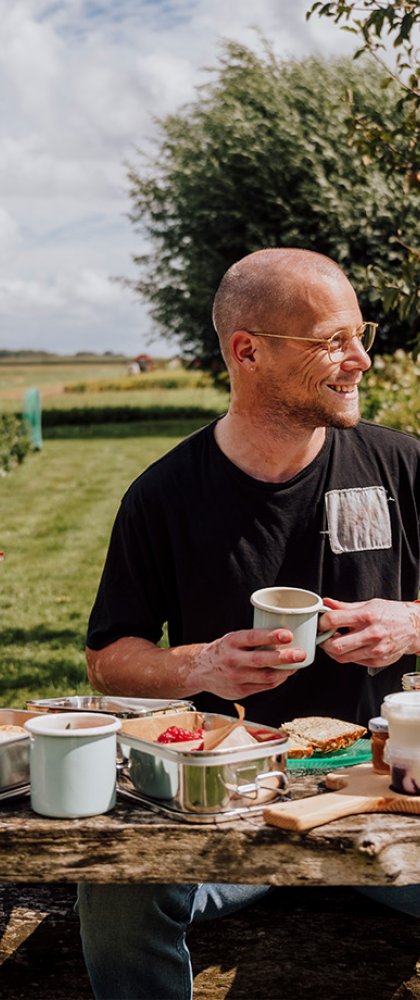 Man enjoys table full of local produce at the Zuiderkrib Dijkhuisje in Kraggenburg, Flevoland