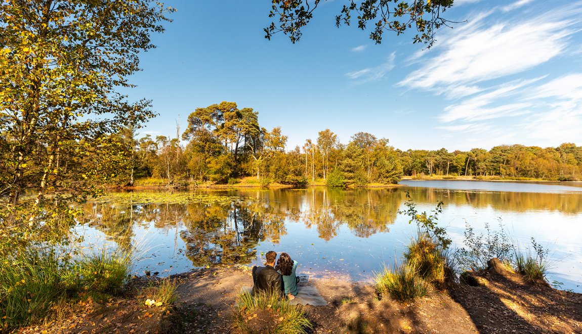 Oisterwijk lake in autumn with couple by the water Oisterwijk lake in autumn with couple by the water