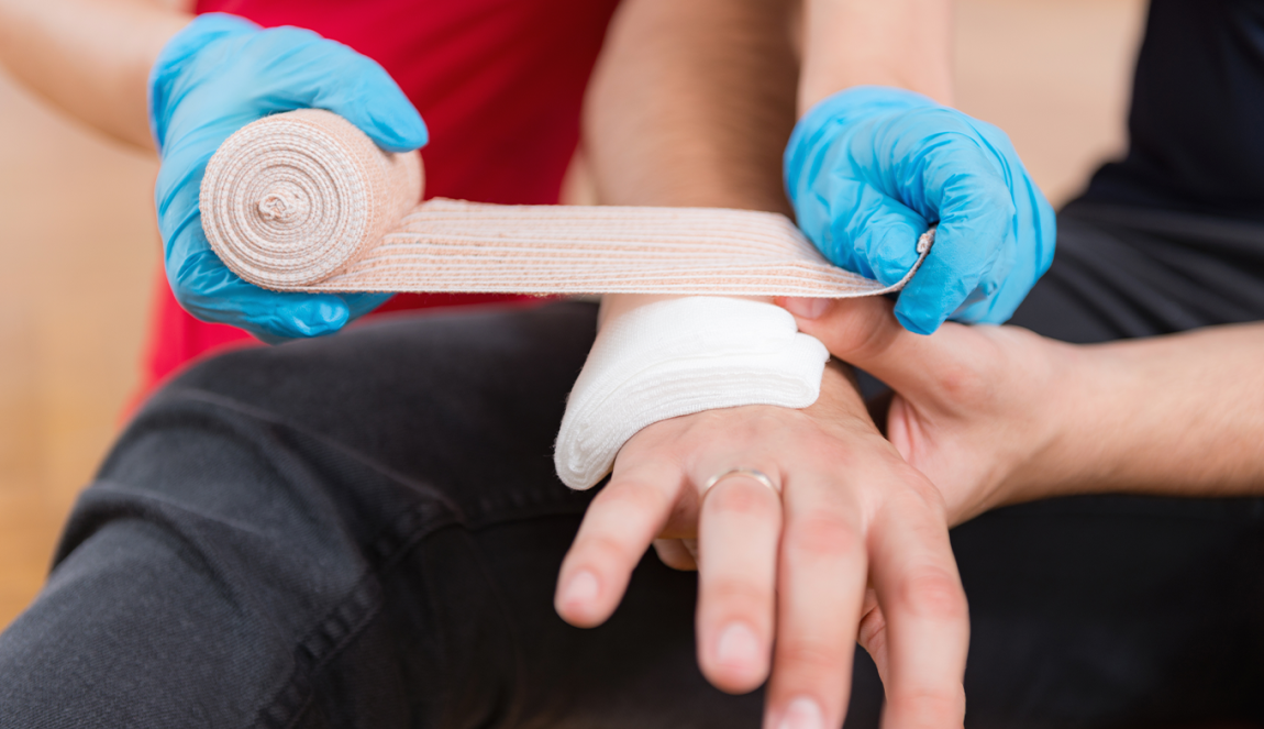 First aid training: blue gloves hand bandaging 