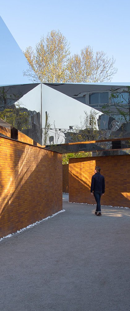 Visitor views walls full of names at Namenmonument Amsterdam