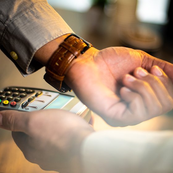 Hand with a smartwatch making payment transaction.
