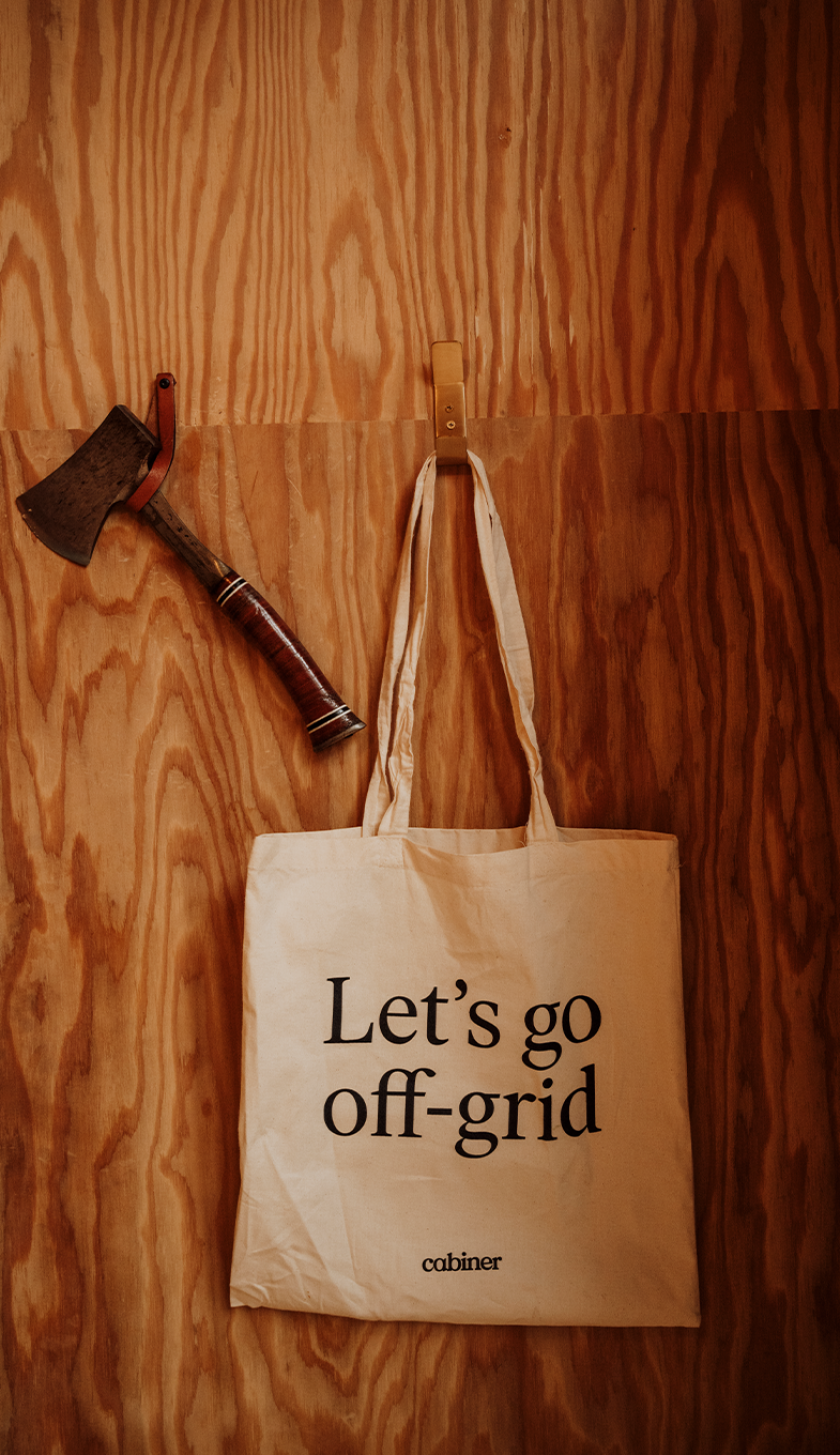 Axe and bag with text 'Let's go off-grid' at Cabiner